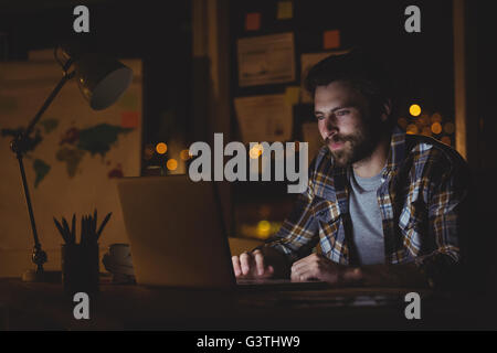 Businessman using laptop at night Stock Photo