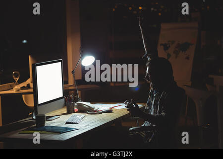 Businessman playing computer games at night Stock Photo