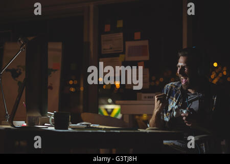 Businessman playing computer games at night Stock Photo