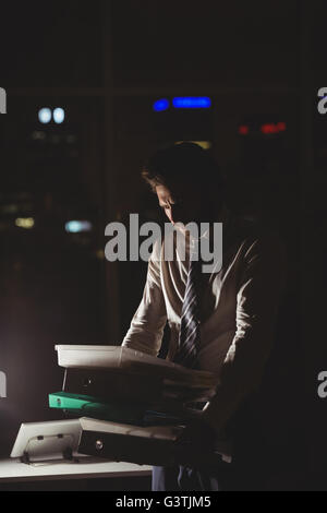Businessman carrying folder at night Stock Photo