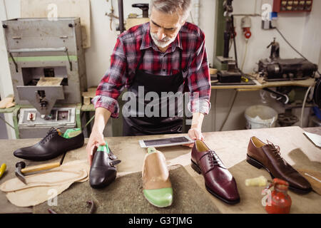 Cobbler using a tablet computer Stock Photo