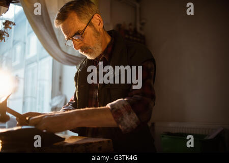Low angle view of cobbler making a shoe with a hammer Stock Photo