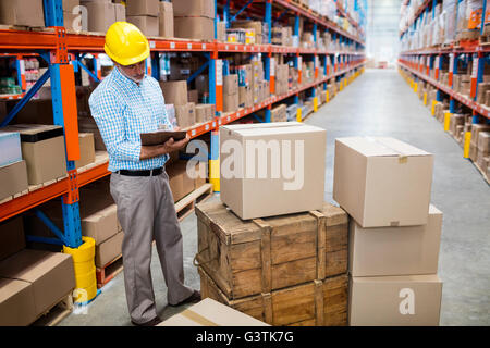 Warehouse worker checking his list on clipboard Stock Photo