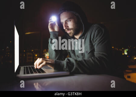Hacker using a laptop Stock Photo