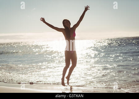 Young woman jumping on beach Stock Photo