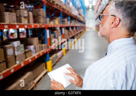 Focus on foreground of warehouse manager taking notes Stock Photo