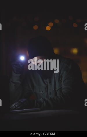Hacker using a laptop Stock Photo