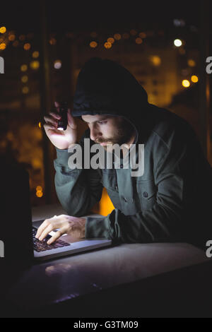 Hacker using a laptop Stock Photo