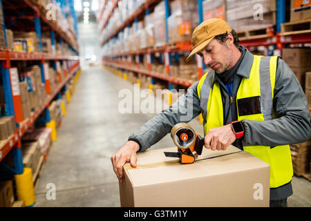 Man worker taping up a box Stock Photo