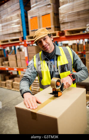 Portrait of man worker taping up a box Stock Photo
