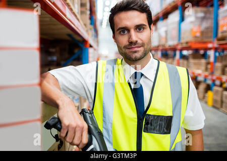 Warehouse manager with yellow coat and scanner in warehouse Stock Photo