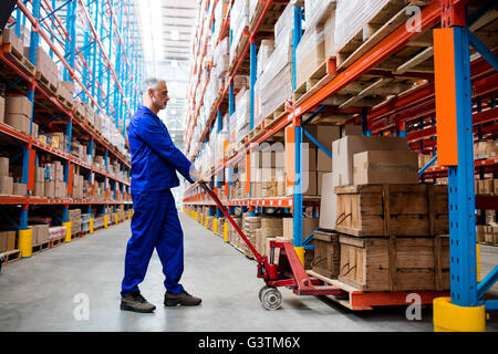 Man worker using pallet truck Stock Photo
