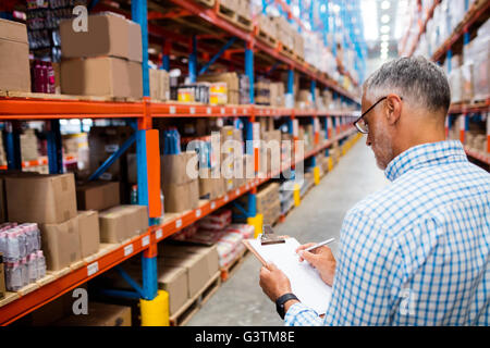 Manager writing on his clipboard Stock Photo