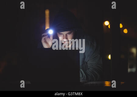 Hacker using a laptop Stock Photo