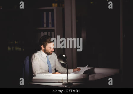 Overworked businessman working at night Stock Photo