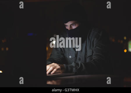 Hacker using a laptop Stock Photo