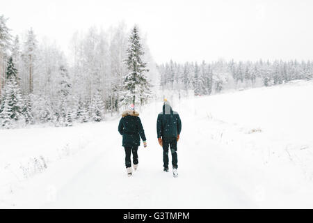 Finland, Jyvaskyla, Saakoski, Young couple walking along road covered with snow