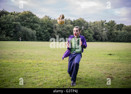 A boy dressed in costume for Halloween Night about to catch a skull. Stock Photo