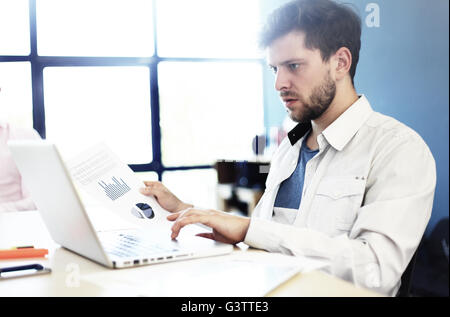 Elegant businessman analyzing data in office Stock Photo