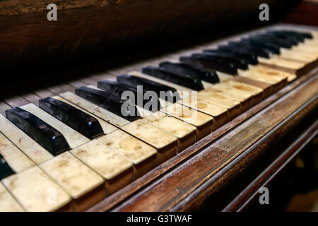 Dirty dusty antique piano in shed. Shallow DOF Stock Photo