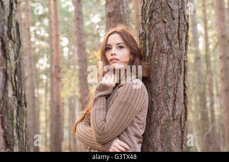 A young woman communing with nature in a forest in Autumn. Stock Photo