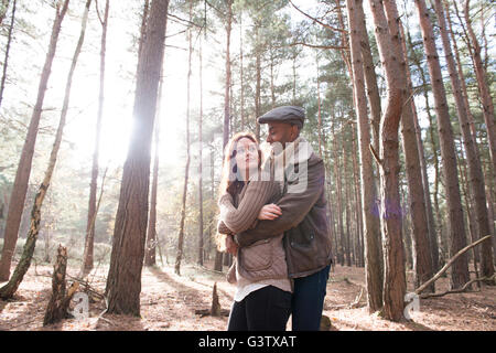 A young couple cuddling on a forest walk in Autumn. Stock Photo