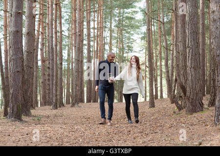 A young couple communing with nature on a forest walk in Autumn. Stock Photo