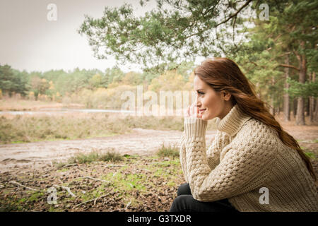 A young woman communing with nature on a forest walk in Autumn. Stock Photo