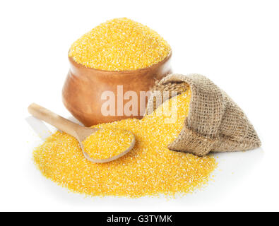 Uncoocked corn grits polenta in bowl and spoon close-up isolated on white background Stock Photo