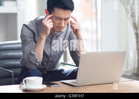 Tired young man working in office Stock Photo