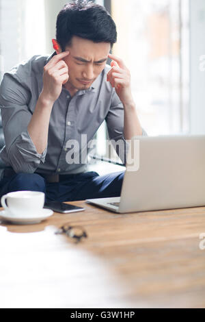 Tired young man working in office Stock Photo