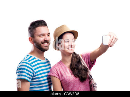 Couple in summer clothes with smartphone, taking selfie Stock Photo