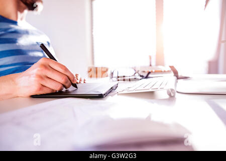 Unrecognizable man working from home writing on graphic tablet Stock Photo