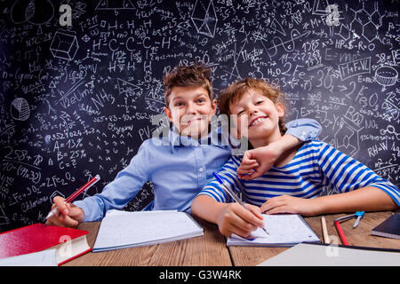 School boy and girl at the desk, big blackboard Stock Photo