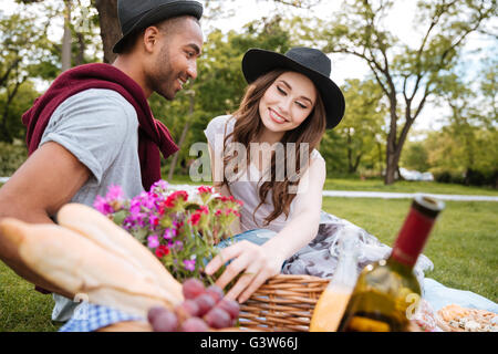 Closeup of happy beautiful young couple having fun on picnic in park Stock Photo