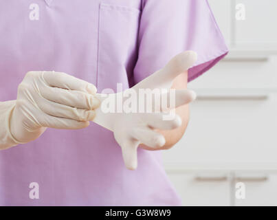 Nurse putting on latex gloves Stock Photo