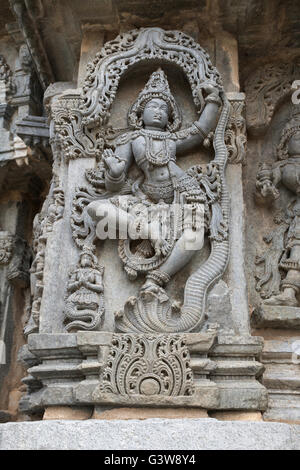 Ornate wall panel reliefs depicting Krishna dancing on the head of serpant Kalia. Kedareshwara temple, Karnataka, India Stock Photo