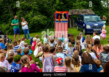 Children Watch A Traditional Punch and Judy Show At The Annual Medieval Fair Of Abinger, Surrey, UK Stock Photo