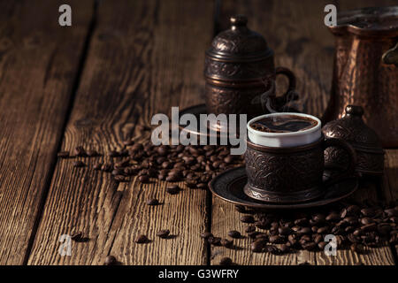 Two coffee cups and a Turkish coffee pot on wooden background