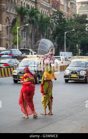 MUMBAI, INDIA - OCTOBER 9, 2015: Unidentified women carrying weights in Mumbai. People have carried burdens balanced on top of t Stock Photo