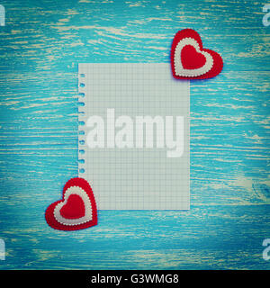A blank sheet of paper and heart on a wooden background. Photo in vintage style Stock Photo
