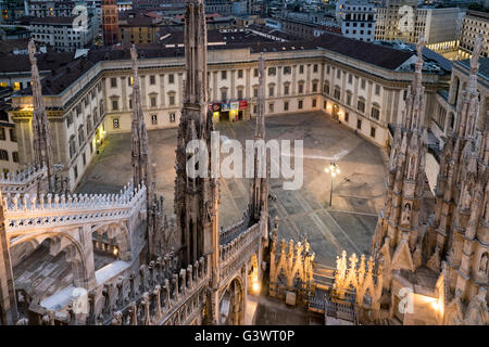 Italy, Milan Cathedral, Metropolitan Cathedral-Basilica of St Mary of the Nativity, Palazzo Reale and the square in front as seen from the roof of the Duomo, among the marble spire; bg.:  Bell Tower of the Church of Saint Gotthard of Hildesheim Stock Photo