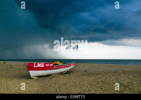 Boat on Cley beach North Norfolk and coming summer thunder storm Stock Photo