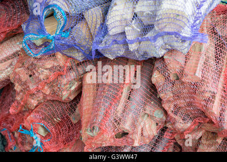 the Firewood in net bag sold in the store Stock Photo