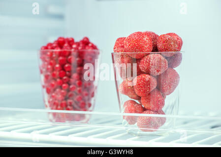 Refrigerator shelf with organic juicy strawberries in bio recycled paper  boxes and homemade natural milk yogurt. Fridge filled with berries in  cardboard containers. Healthy and eco friendly food diet Stock Photo by ©