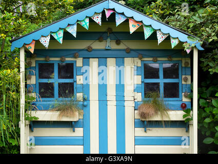 Striped blue and cream painted summer house in a cottage garden. Ashton Under Hill, Wychavon district, Worcestershire, England Stock Photo