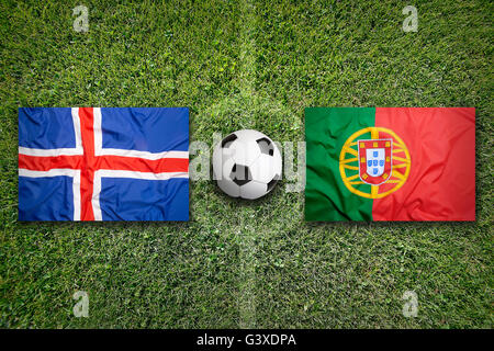 Iceland vs. Portugal flags on green soccer field Stock Photo