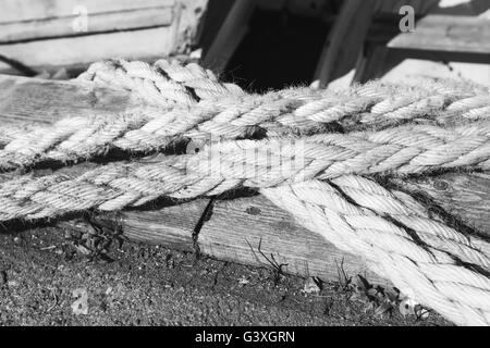 Closeup of strong string white ropes on background sea and deck