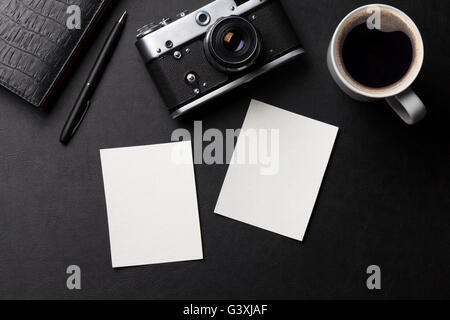 Office desk with photo frames, camera, coffee and notepad. Top view with copy space Stock Photo