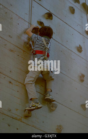 a little boy free climbing Stock Photo